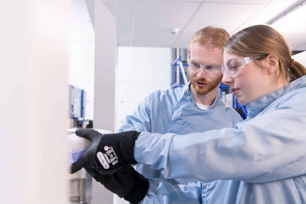 Two scientists work get samples out of the freezer