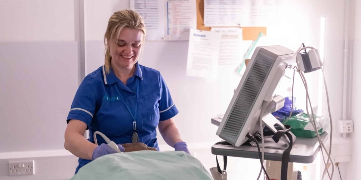 A nurse smiles down at a participant as she scans