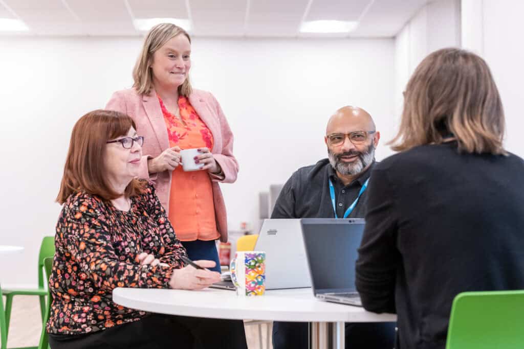 four colleagues have an informal meeting whilst drinking coffee