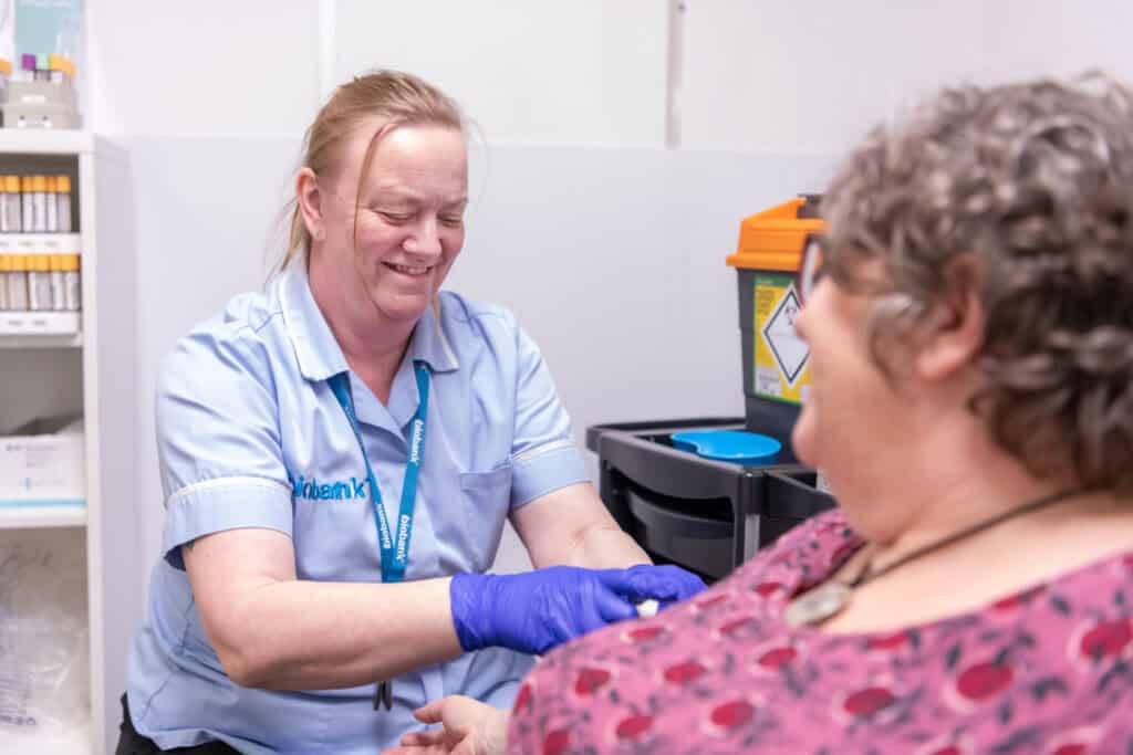 A nurse sets up a blood test on a participant