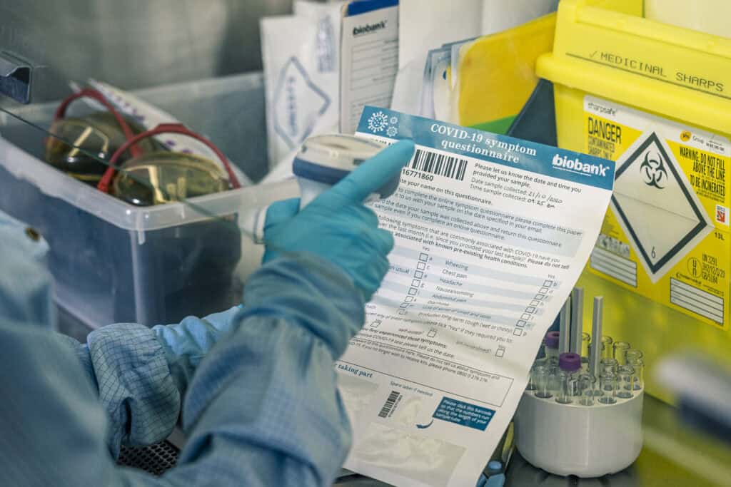 A scientists scans a COVID-19 symptom questionnaire form