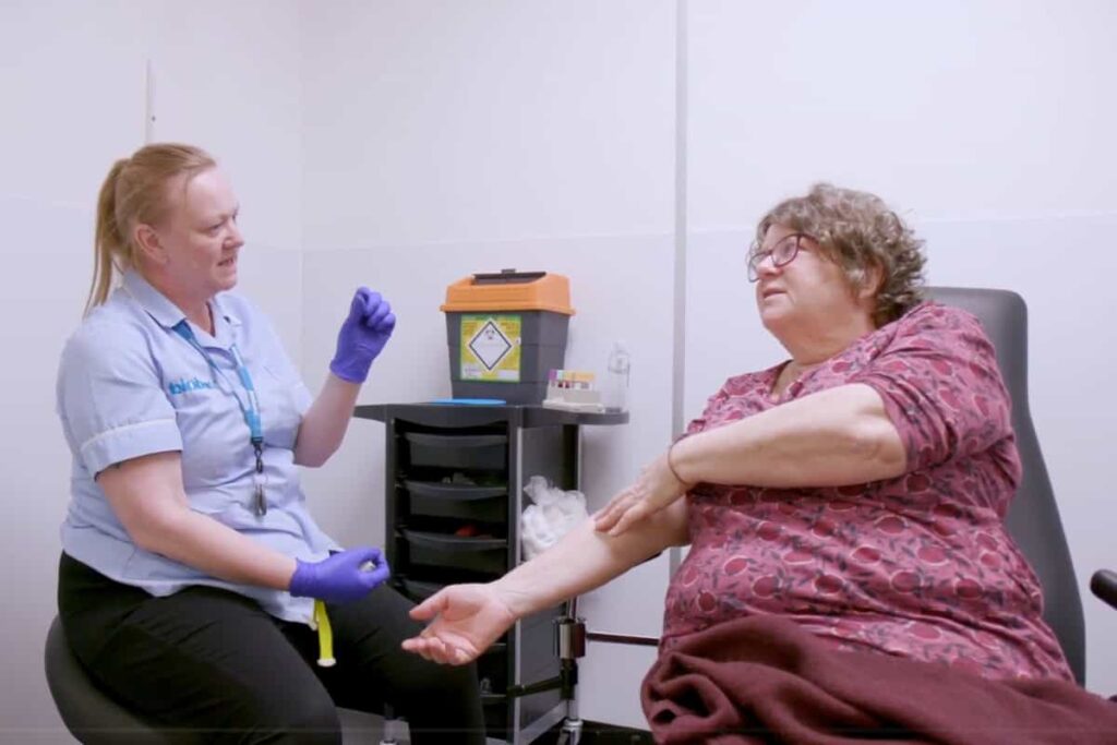 A nurse speaks to a participant after having her blood taken