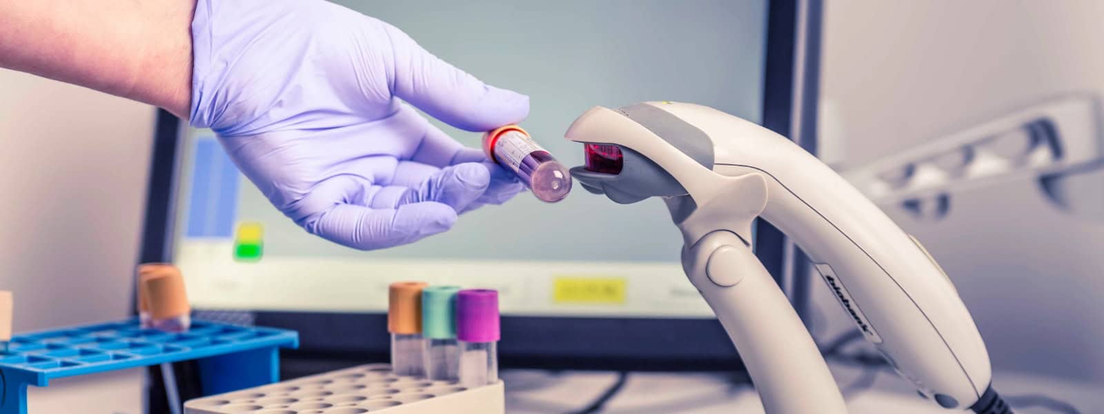 A gloved hand scans a UK Biobank sample
