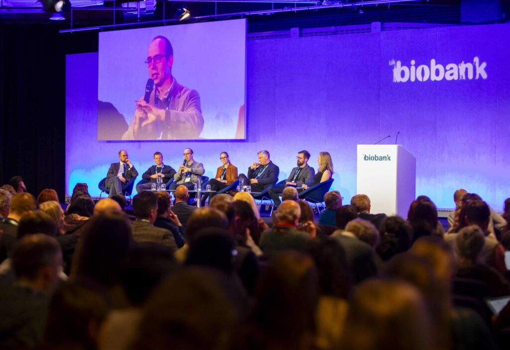 A panel session taking place at the UK Biobank Scientific Conference 2025 - seven experts sit on stage