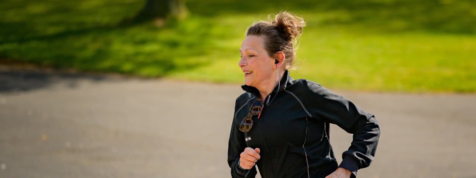 A woman in exercise clothing runs in a park