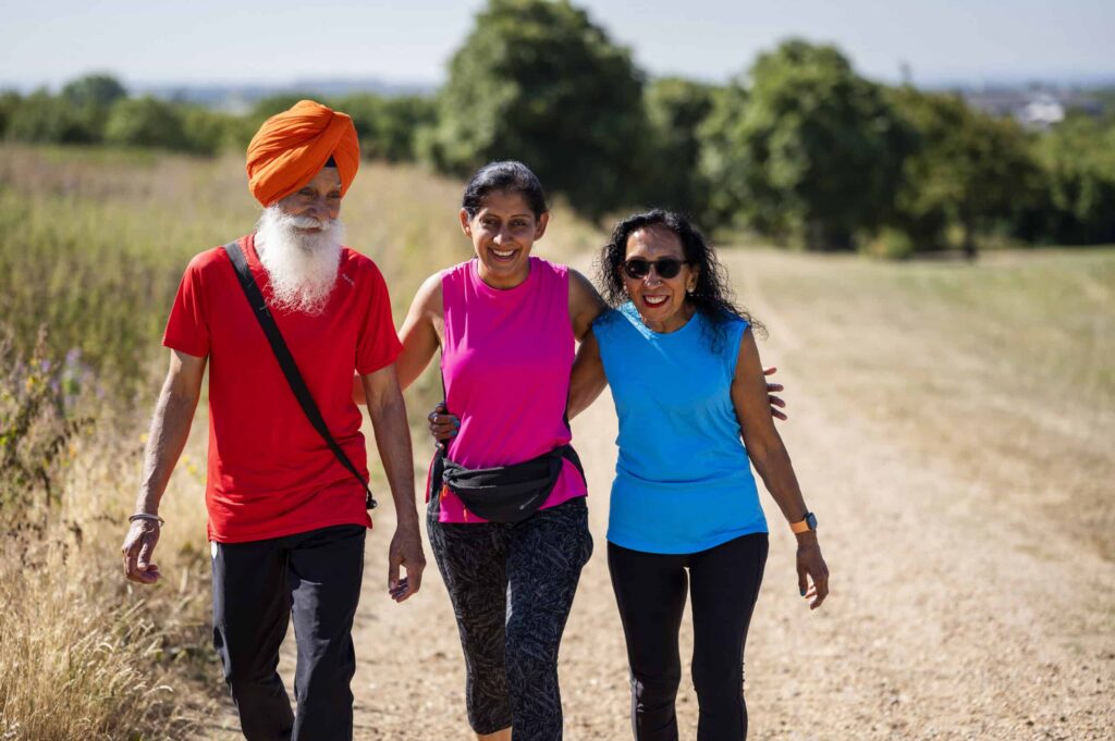 A family walk outside in sports clothes through a park