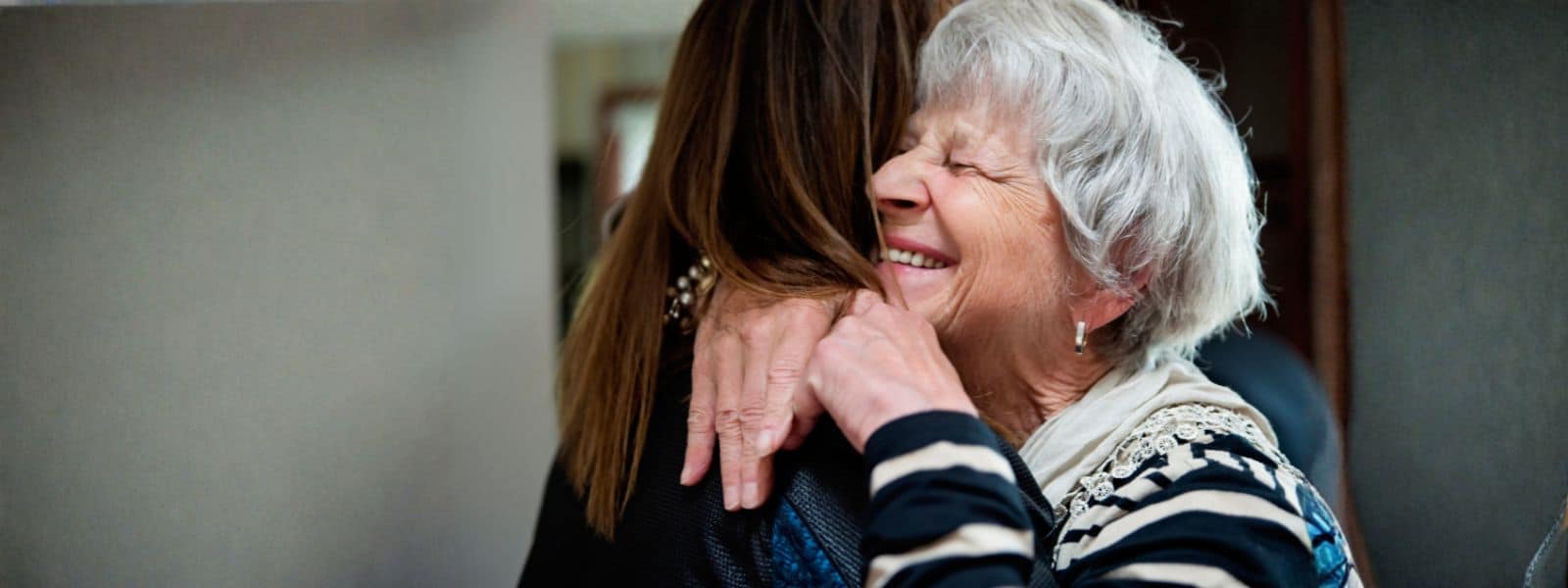 An older and a younger woman hugging.